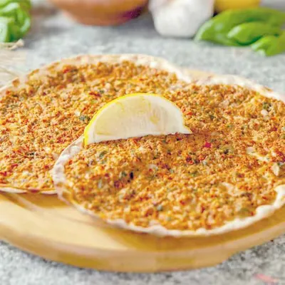 Lahmajo with a lemon wedge on a wooden board